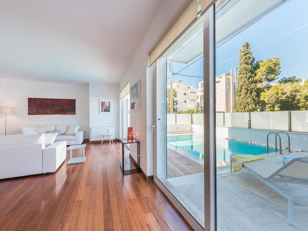 Greek Villa sunrelax with Private Pool Jacuzzi في أثينا: غرفة معيشة مع أريكة بيضاء ومسبح