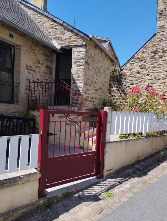 un portail rouge devant une maison dans l'établissement Maison du martin pêcheur à Lannion, à Lannion