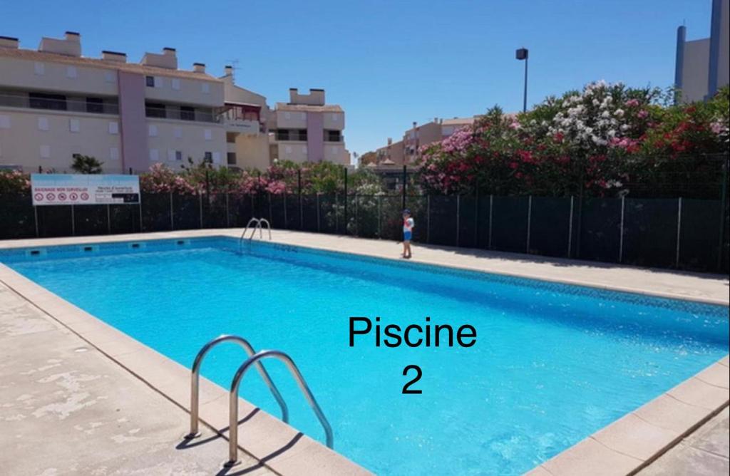 une piscine avec l'abréviation pstine à côté d'une photo dans l'établissement Flore, au Grau-du-Roi