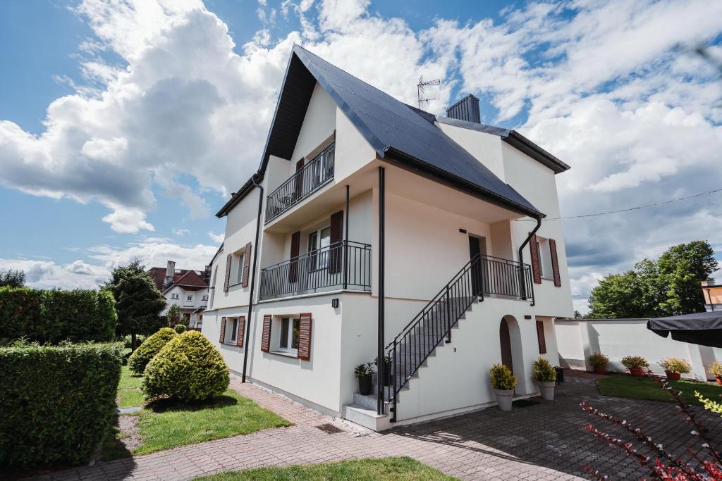 una casa blanca con techo negro en Willa Zaciszne Centrum Augustów, en Augustów