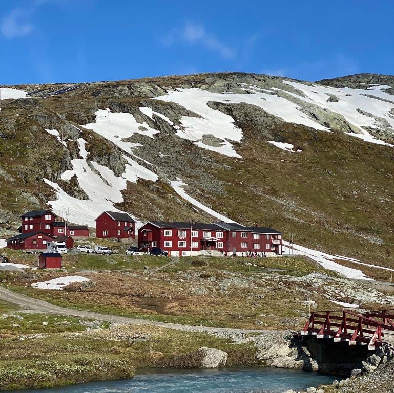 a red building on a mountain with snow on it at Krossbu in Boverdalen