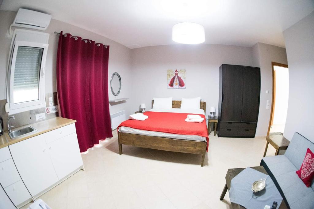um quarto com uma cama com um cobertor vermelho em Mirmidones Anesis em Agreliá