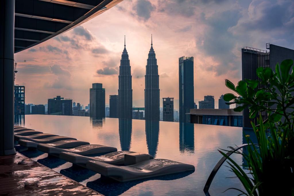 een zwembad met uitzicht op de Petronas-torens bij Eaton Residence KLCC in Kuala Lumpur