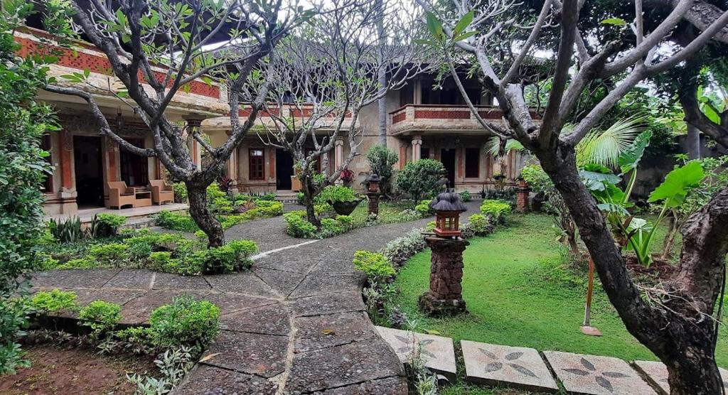 a garden with a fire hydrant in front of a building at Rambutan Hotel in Lovina