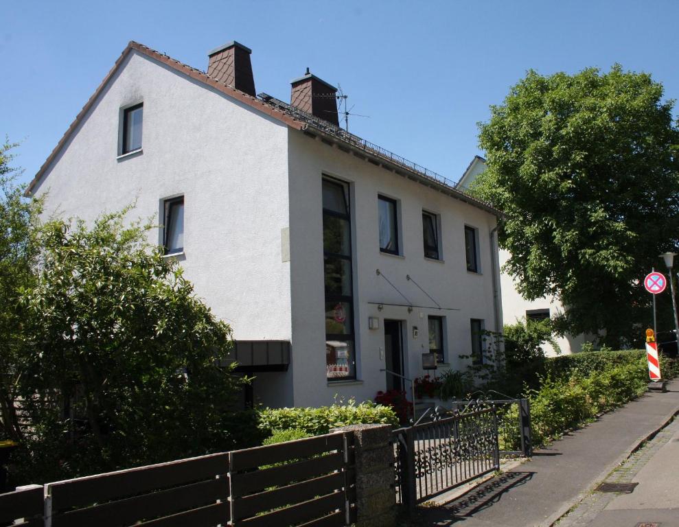 una casa blanca con una valla delante en Das Blaue Haus - Ferienwohnung Schönherr en Kassel