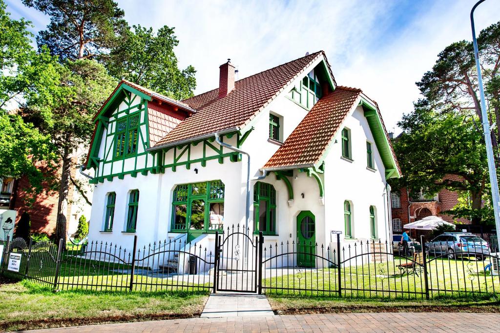 Biały dom z czerwonym dachem w obiekcie Willa Kryniczanka w mieście Krynica Morska