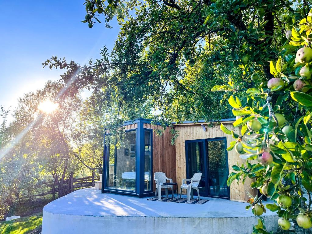 a glass house with a table and chairs in front of it at Elysian Fields - The Island Tiny House in Sadu