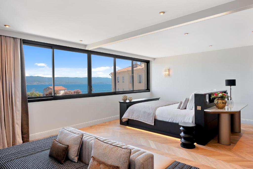 a bedroom with a bed and a large window at Hotel San Carlu Citadelle Ajaccio in Ajaccio