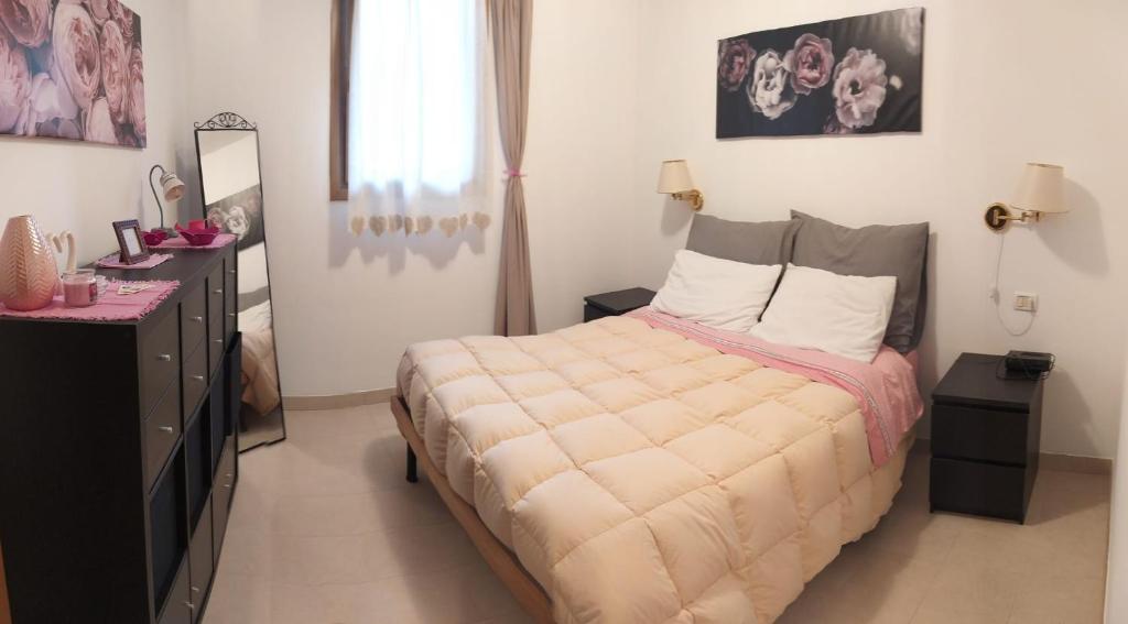 a bedroom with a bed with a dresser and a mirror at Appartamento Dellantonio in Predazzo