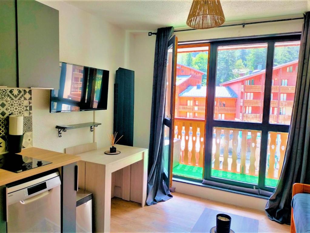 cocina con ventana grande con vistas a un edificio en Valfrejus Studio 19m2 cosy 60 m des pistes draps non compris, en Modane