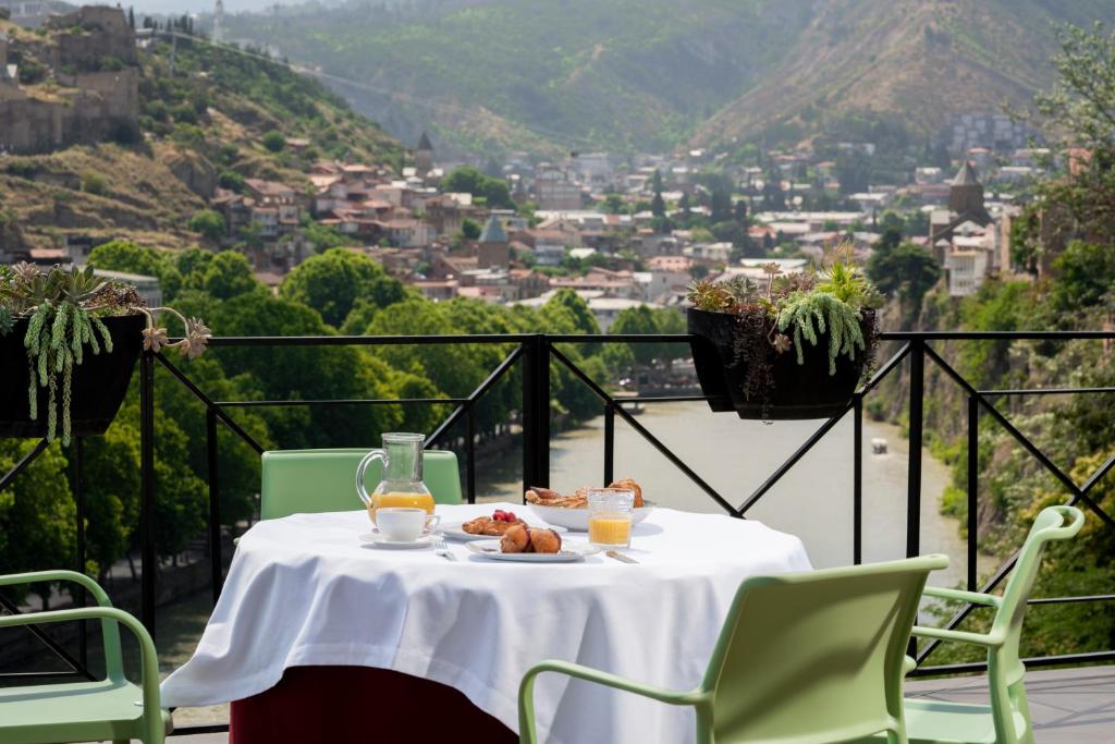 una mesa con un plato de comida y bebida en el balcón en Margot Old Tbilisi en Tiflis