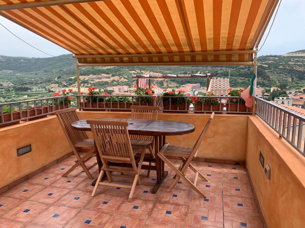 einen Tisch und Stühle auf einem Balkon mit Aussicht in der Unterkunft Casa vacanze Muruidda in Bosa