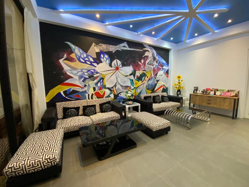 Zimmer mit Sofas und einem großen Wandgemälde in der Unterkunft Beauty House Homestay in Magong