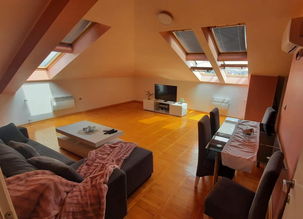 ein Wohnzimmer mit einem Sofa und einem Tisch in der Unterkunft Loft apartman in Jagodina