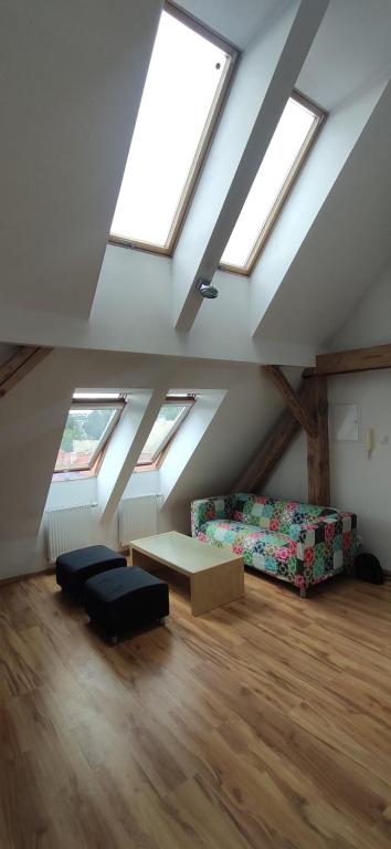 Zimmer im Dachgeschoss mit Oberlichtern, einem Sofa und einem Tisch in der Unterkunft Apartament Gliwice Centrum in Gliwice