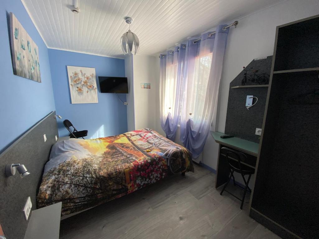 um pequeno quarto com uma cama e uma secretária em Hôtel Le Bambi em Baume-les-Dames