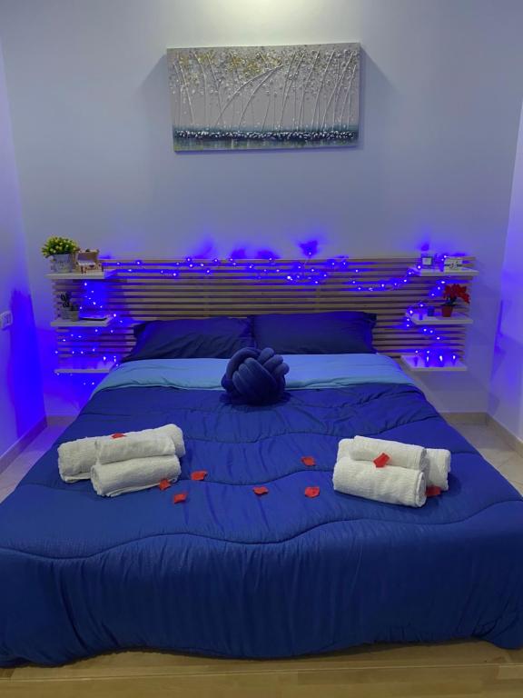 - une chambre bleue avec un lit et 2 serviettes dans l'établissement Casa Nanà, à Pouzzoles