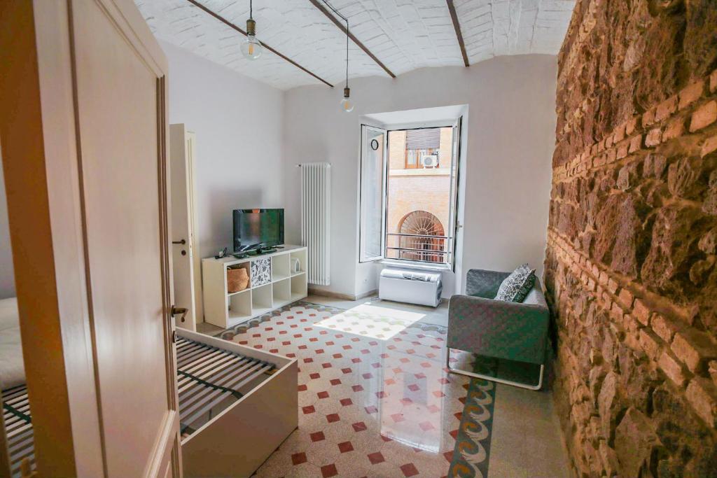 Pokój z ceglaną ścianą i salonem w obiekcie CAIROLI BOUTIQUE APARTMENT w Rzymie