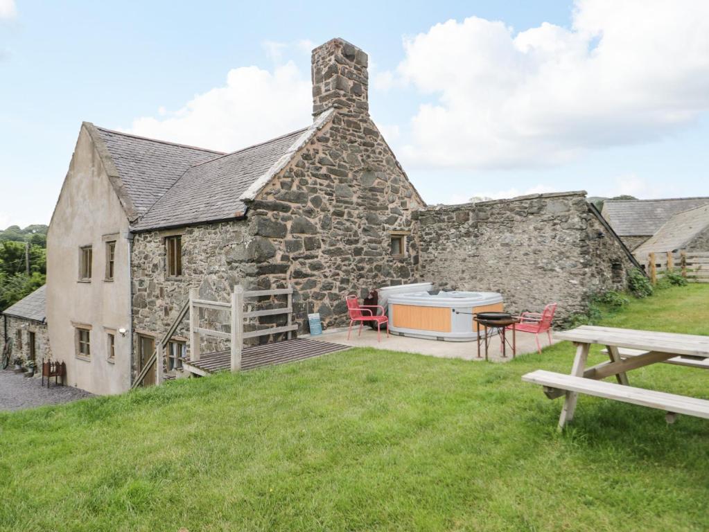 Cette ancienne maison en pierre comprend une table de pique-nique et un grill. dans l'établissement Yr Hen Dy, à Colwyn Bay