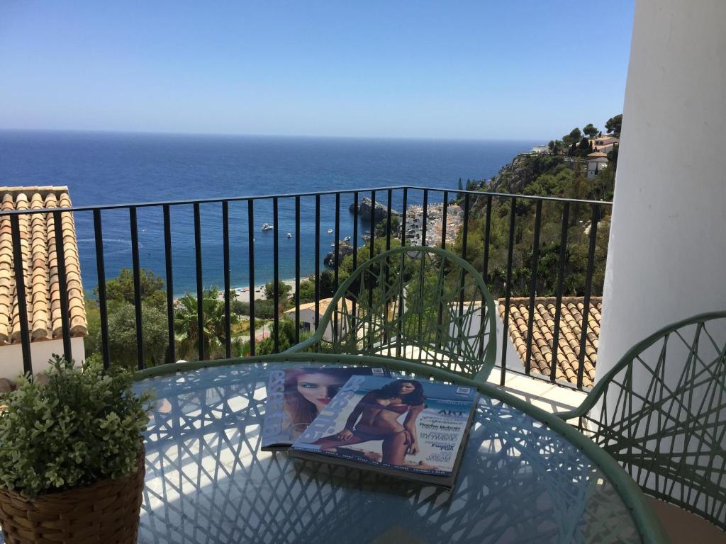 a book sitting on a glass table on a balcony at Marina del Este sea view half villa in Almuñécar