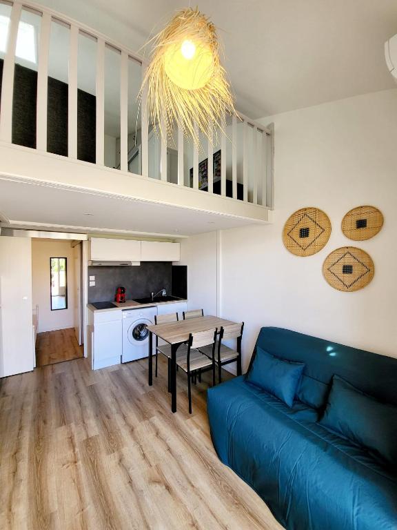 salon z niebieską kanapą i stołem w obiekcie Petite maison de vacances au bord de l'eau w mieście Leucate