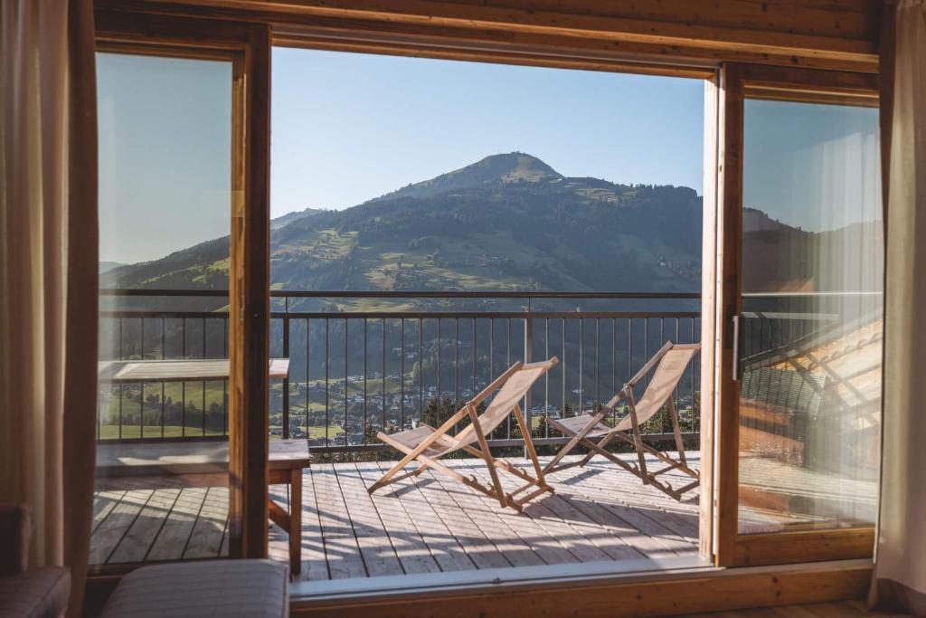 a balcony with two chairs and a view of a mountain at Almlodge Westendorf in Westendorf