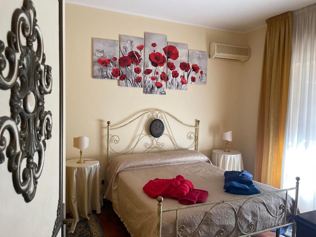 una camera da letto con un letto con fiori rossi di Lady House a Reggio di Calabria