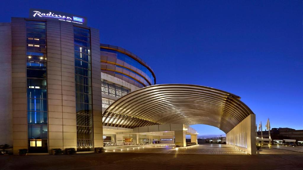 a building with an archway in front of it at night at Radisson Blu Hotel MBD Ludhiana in Ludhiana