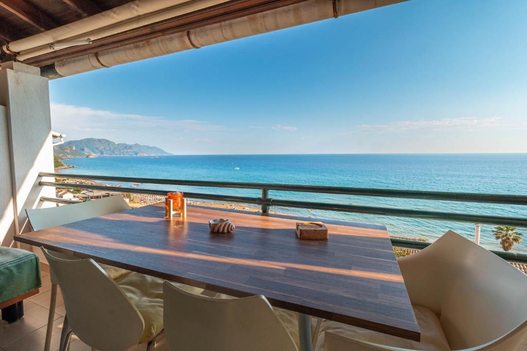 a table and chairs on a balcony with the ocean at Glyfada Home 113 by New Era in Menigos Resort Apartments in Glyfada