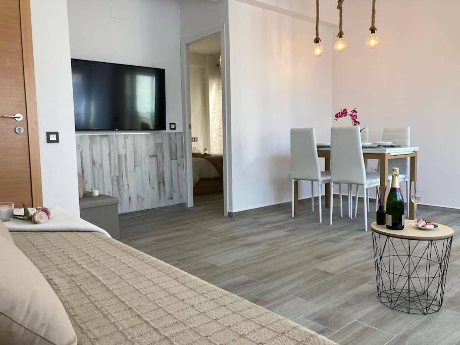 1 dormitorio con sala de estar con mesa y TV en Coqueto apartamento de Playa con Piscina y Terraza, en Valencia