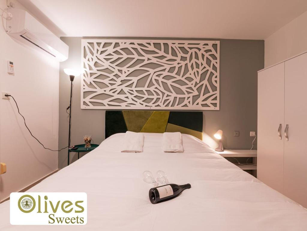 a bedroom with a white bed with a phone on it at Olives sweets in Arad