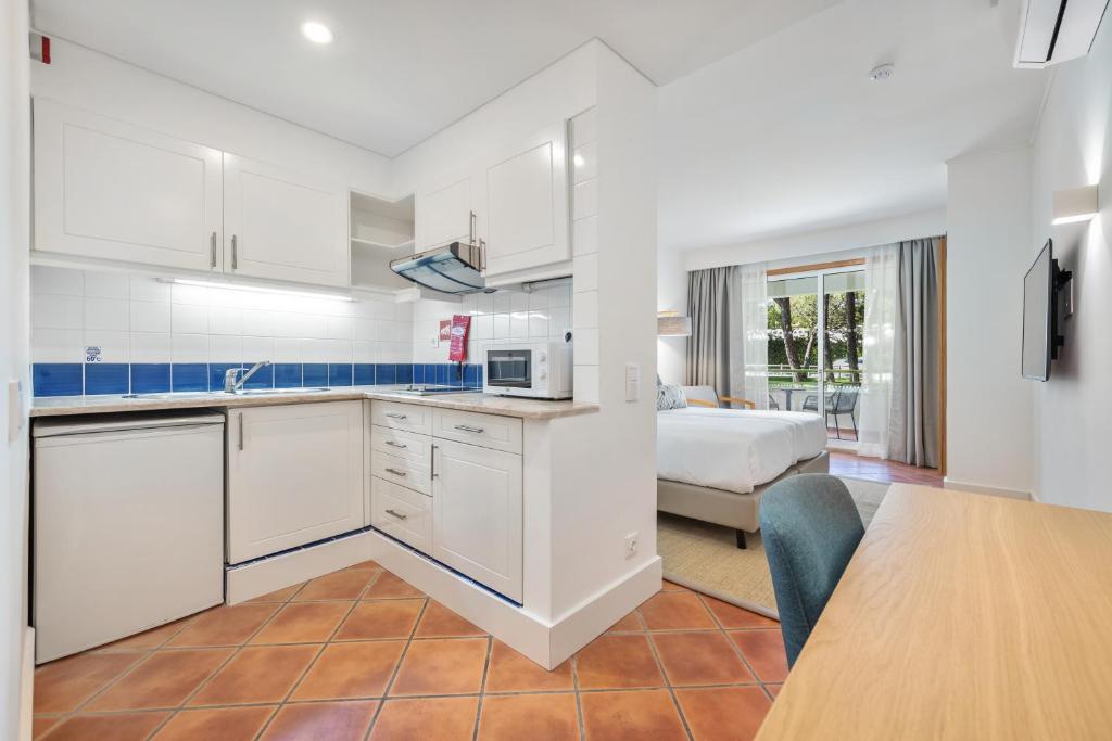 a kitchen with a table and a bed in a room at The Patio Suite Hotel in Albufeira