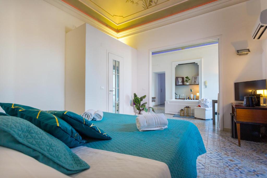 sypialnia z dużym łóżkiem z niebieską pościelą w obiekcie Palazzo Bruca Catania w Katanii