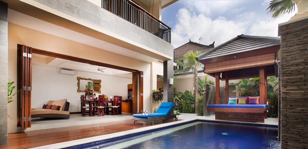 a villa with a swimming pool and a living room at The oasis retreat seminyak in Seminyak