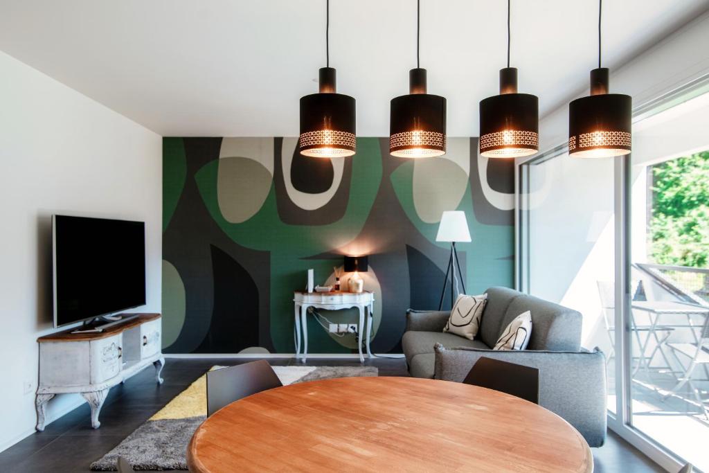 ein Wohnzimmer mit einem Tisch und einem TV in der Unterkunft Liom Apartment by Quokka 360 - one-bedroom design apartment with balcony in Gudo