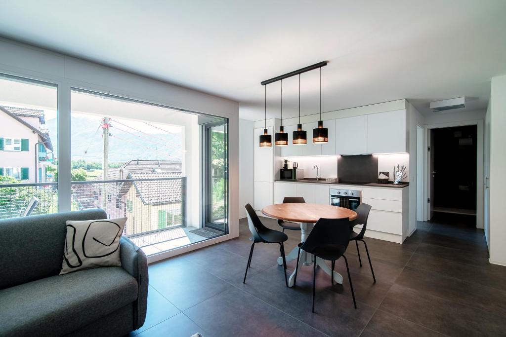 Il comprend une cuisine et un salon avec une table et des chaises. dans l'établissement Liom Apartment by Quokka 360 - one-bedroom design apartment with balcony, à Gudo