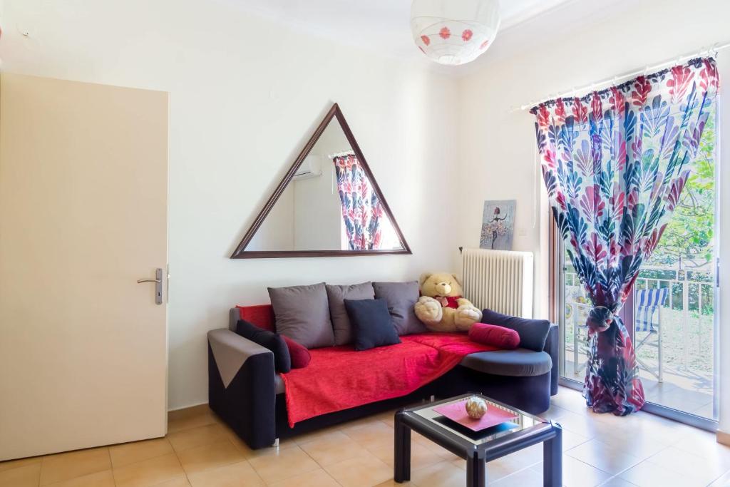 - un salon doté d'un canapé avec un ours en peluche dans l'établissement Mema's Tranquil Apartment in Patra, à Patras