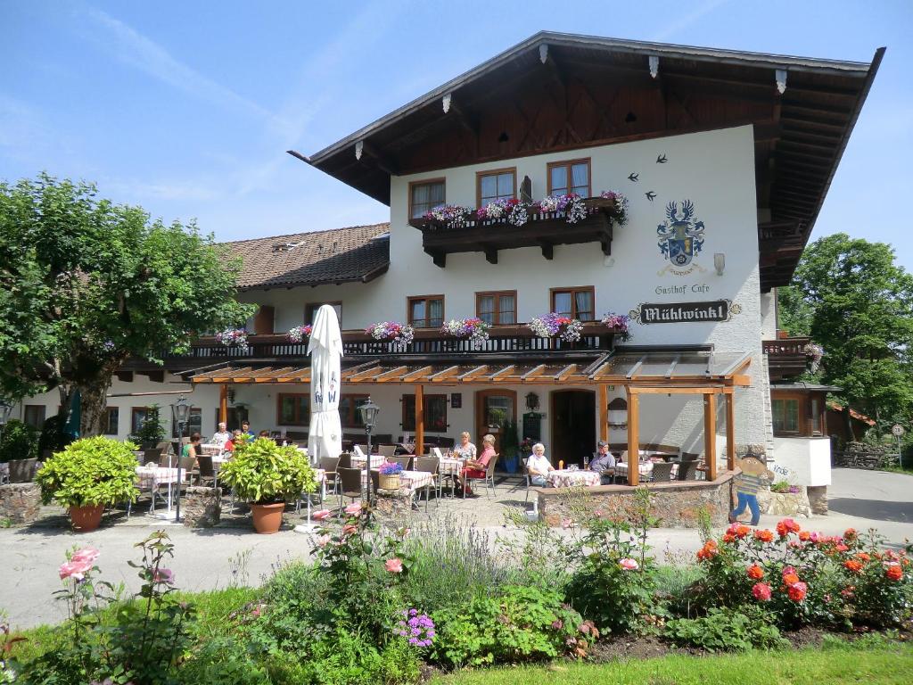 a building with people sitting at tables in front of it at Gasthof Mühlwinkl in Staudach-Egerndach