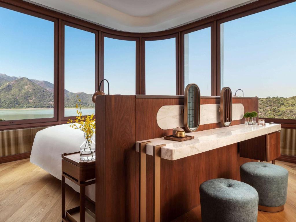 a bedroom with a bed and a large window at The Silveri Hong Kong - MGallery in Hong Kong