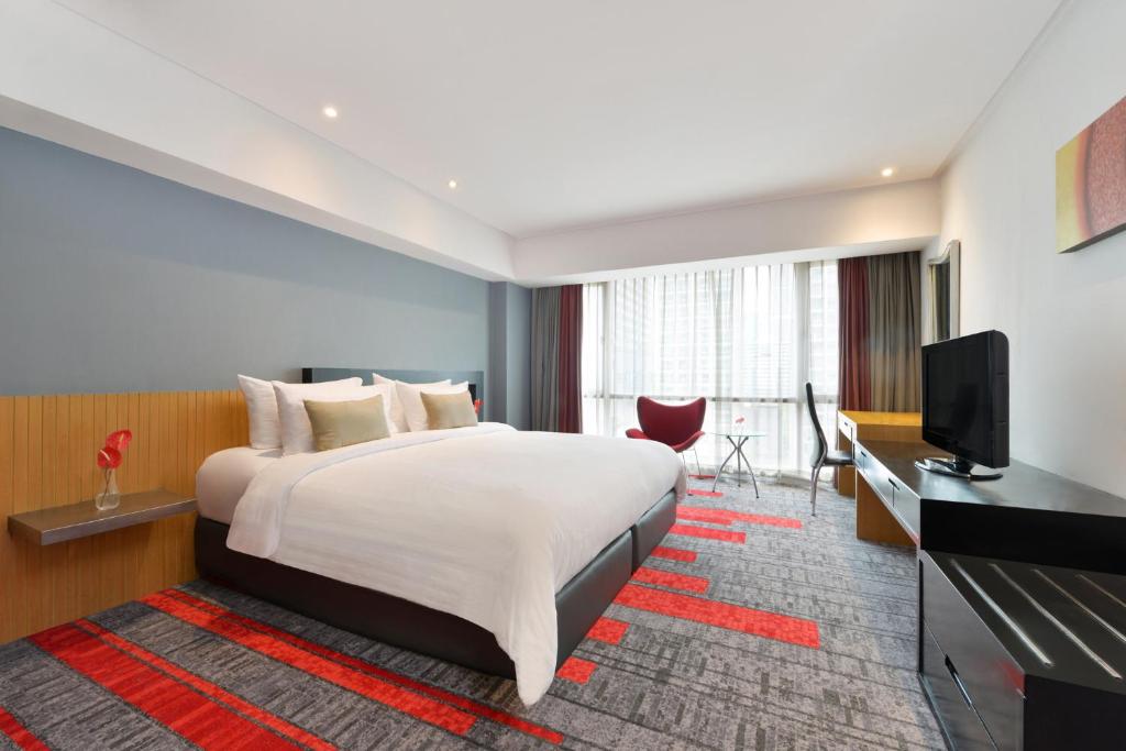 a hotel room with a large bed and a large window at BelAire Bangkok Sukhumvit - SHA Extra Plus in Bangkok