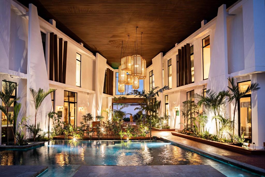 um pátio interior com uma piscina num edifício em La Maison Palmier Abidjan, a Member of Design Hotels em Abidjan