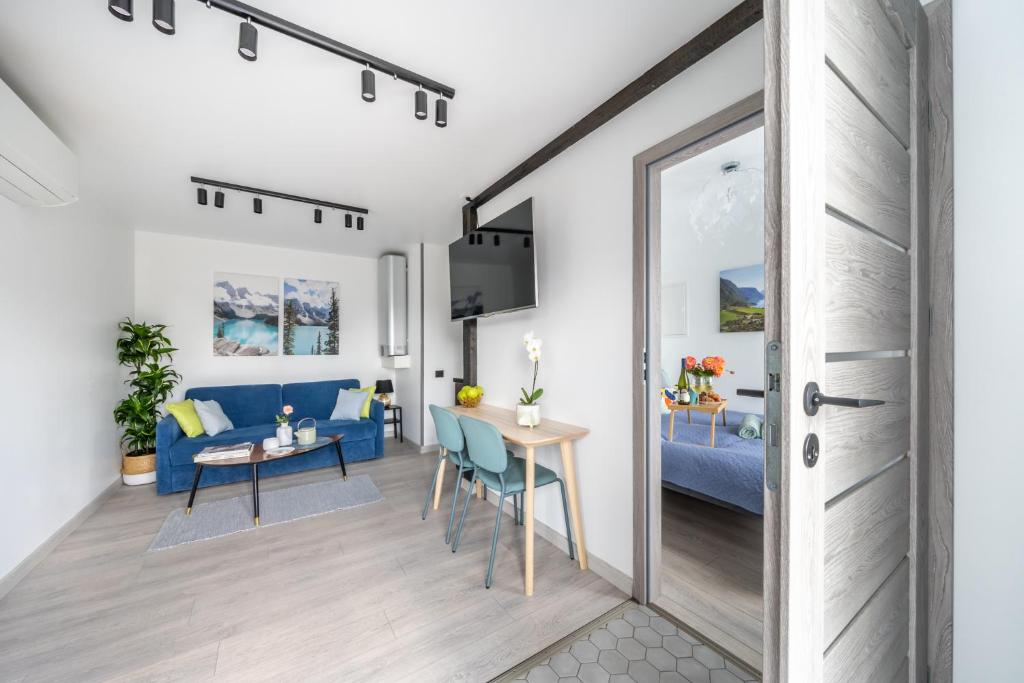 a living room with a blue couch and a table at Family Garden House with Free Private Parking & Playground in Rīga