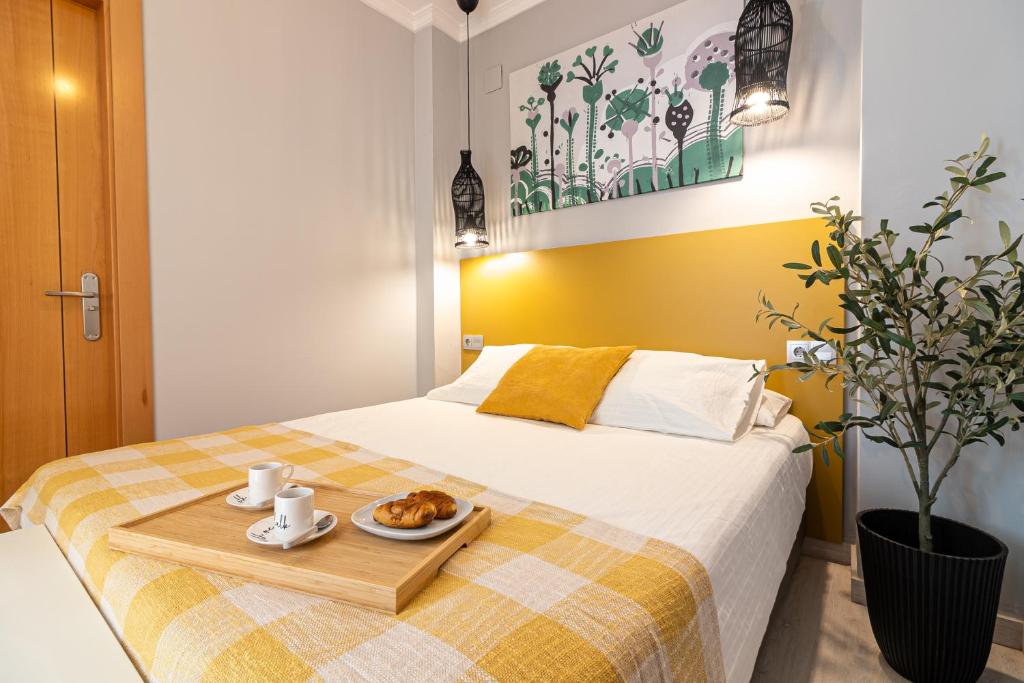 łóżko z tacą z talerzem jedzenia w obiekcie Malaga Center Flat - SoHo Center Apartments w Maladze