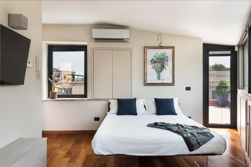 sypialnia z łóżkiem i 2 oknami w obiekcie Idyllia - Penthouse in Navona Area w Rzymie