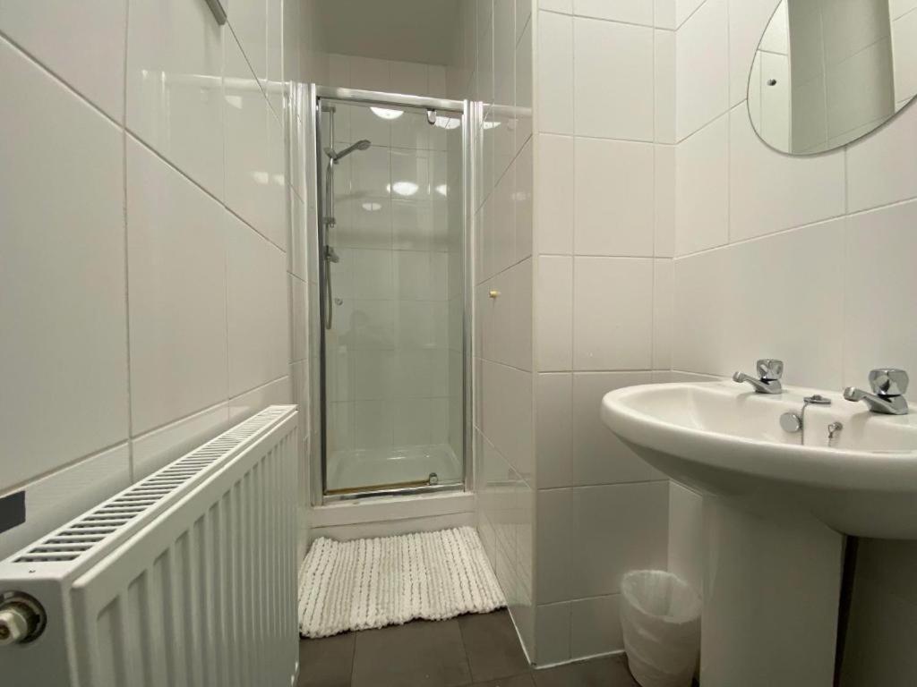 a white bathroom with a shower and a sink at Spacious Victorian Double Room 2 in Doncaster