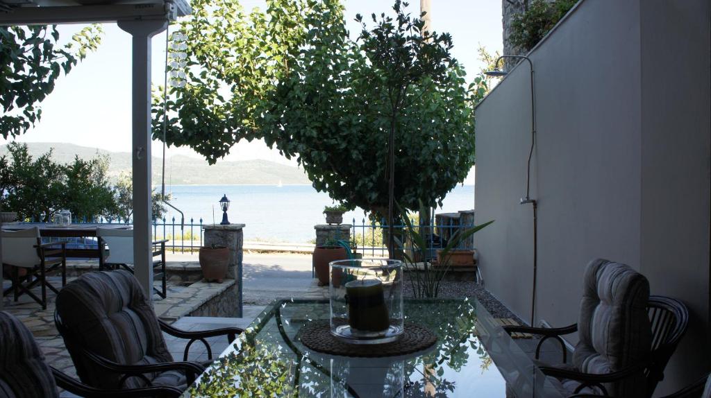a patio with a table and chairs and a view of the ocean at EOΣ in Nikiana
