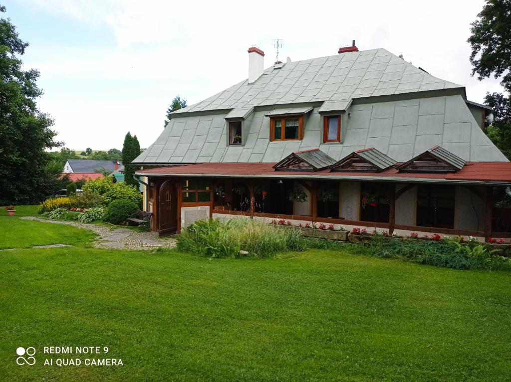 a house with a metal roof on top of a yard at Agroturystyka Ziemowit Karkonosze in Lubawka