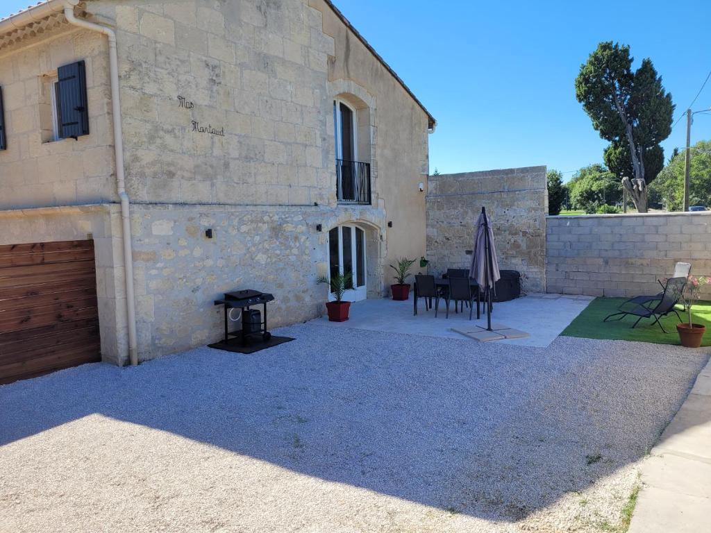 a patio in front of a building with a grill at Appartement dans Mas Provencal in Arles