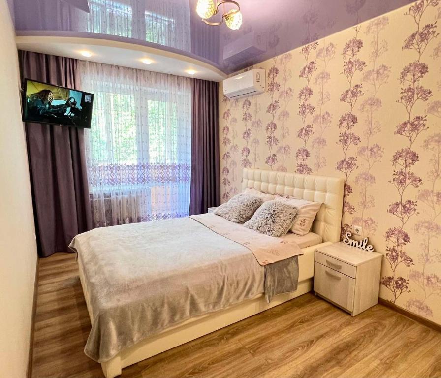 een slaapkamer met een groot bed en een raam bij 2-комн ЛЮКС в центре Вишенки in Vinnytsya