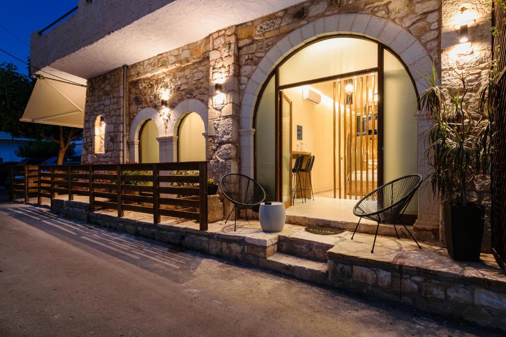 a couple of chairs sitting on the side of a building at Teo Apartments in Georgioupolis